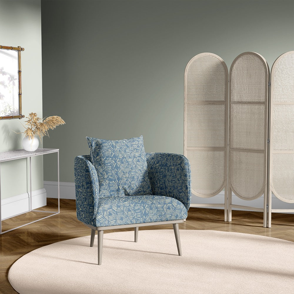 Armchair upholstered in Newton blue geometric upholstery fabric with hexagon print in modern room setting