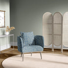 Armchair upholstered in Newton blue geometric upholstery fabric with hexagon print in modern room setting