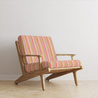Ohio Stripe Coral Velvet Upholstery Fabric room set featuring bold pastel striped velvet on mid-century style armchair