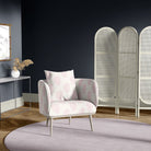 Armchair in paisley blush pink upholstery fabric, featured in a navy-walled room with soft lilac rug and vintage styling