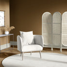 Armchair upholstered in paisley natural upholstery fabric, styled in a warm-toned living room with cane screen and neutral accents