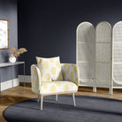 Upholstered chair in paisley ochre yellow upholstery fabric, shown in a dramatic navy room with deep tones and natural wood flooring