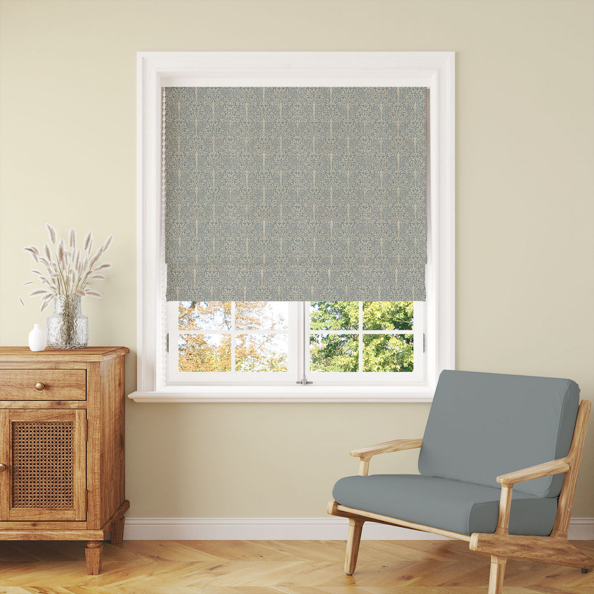 Rowan Leaf Blue linen Roman blind showing the repeating botanical tree design at a window