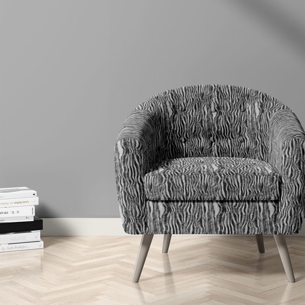 Zebra print velvet fabric on upholstered chair in monochrome animal stripe