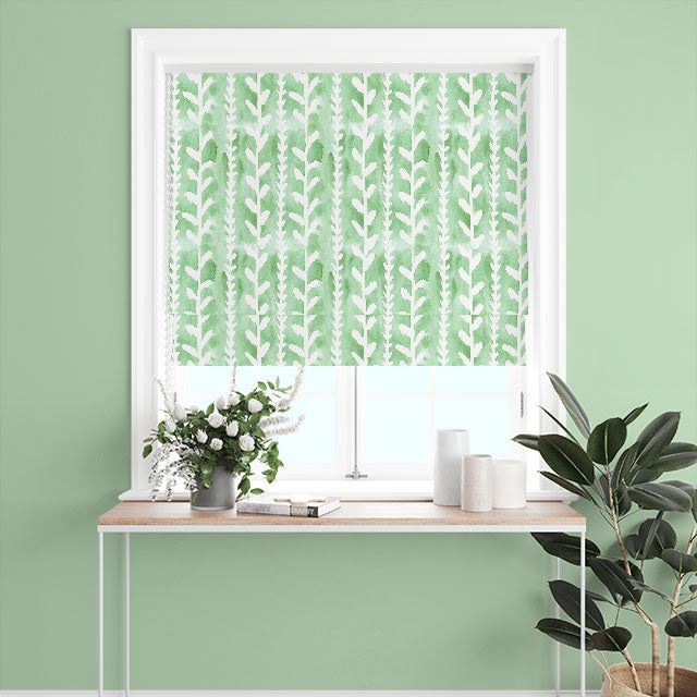 Delilah Cotton Curtain Fabric in Green, hanging gracefully in a well-lit room