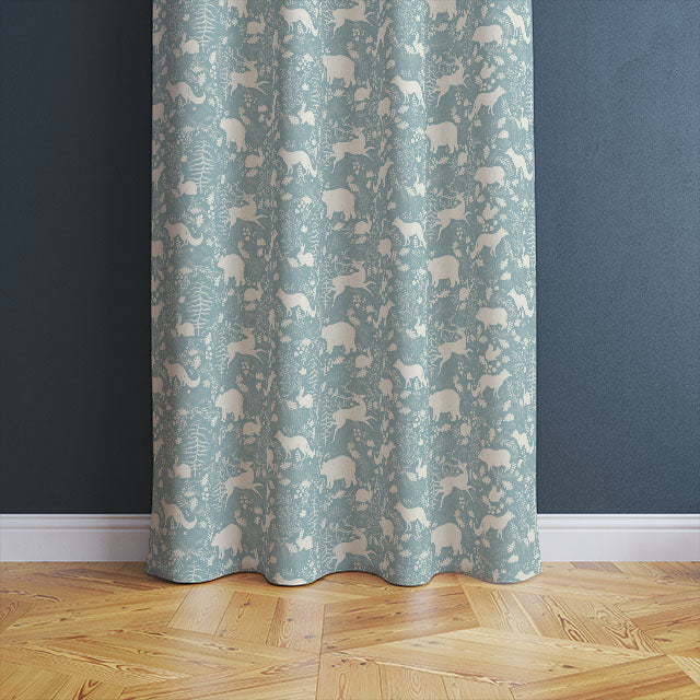 High-quality linen curtain fabric featuring a charming design of forest animals and foliage in a soothing Wedgewood blue color