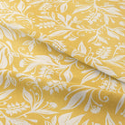 Oxford Leaf Ochre fabric folded to show leaf print on yellow linen blend