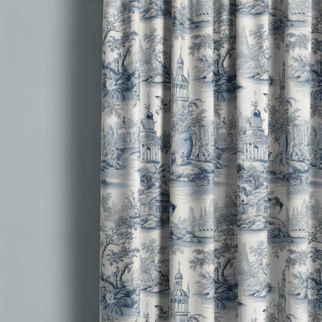 Troyes Toile Linen Curtain Fabric in Blue hanging gracefully in a sunlit room, adding a touch of elegance